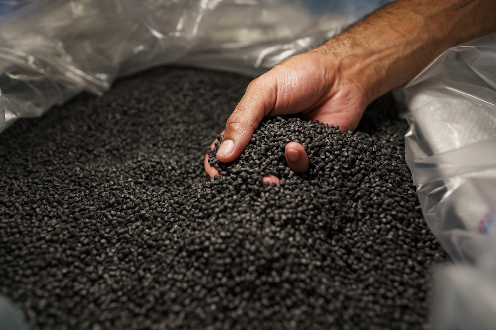 Close up of male hand holding plastic polymer granules